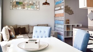 Un salon chaleureux avec un canapé, une table à manger agrémentée d’une boîte décorative et un mur orné de panneaux en bois.