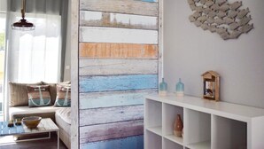 Un salon avec un canapé, une table basse et une étagère blanche.