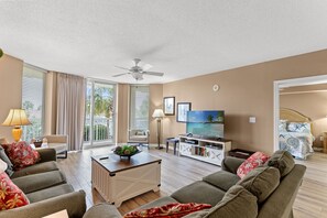 A spacious living room with a ceiling fan, a television, and a comfortable seating area. - Gorgeous condo in Barefoot Golf Resort, marina view +Free Attraction Tickets! (North Myrtle Beach)