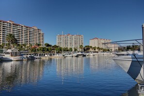A marina with boats docked, surrounded by high-rise buildings with balconies. - Gorgeous condo in Barefoot Golf Resort, marina view +Free Attraction Tickets! (North Myrtle Beach)