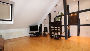 A spacious room with wooden flooring, a television, and a dark wooden cabinet. - ......... Your vacation home to relax, enjoy and relax. (Zell (Mosel))