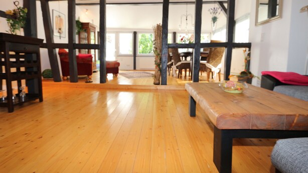 A spacious room with wooden flooring, a large wooden table, and a view of the outdoors through large windows. - ......... Your vacation home to relax, enjoy and relax. (Zell (Mosel))