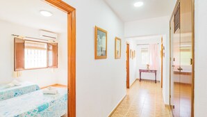 Corridoio di un hotel con due letti, una scrivania e un armadio.