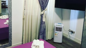 Une chambre d’hôtel avec un lit, une télévision, un radiateur et un miroir.