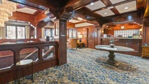 A room with wooden paneling, a patterned carpet, a round table with a vase, and a chandelier. - Availability 11/30/19 to 12/7/19  (Beaver Creek)