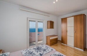 Enjoy a serene retreat with a large wardrobe, bedside table, and a comfortable bed with a floral-patterned bedspread.