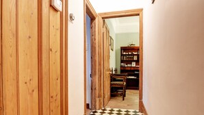 A hallway with wooden doors and a checkered floor leading to a room with a bookshelf. - Victorian townhouse near International Conference Centre / Kings Quarter (Harrogate)