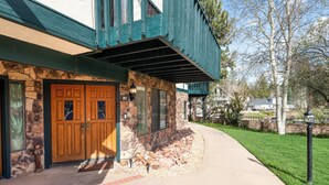 A two-story house with a stone facade, a wooden front door, and a covered porch. - Lakefront Viking Oasis Condo - Lakefront, Indoor Pool, Hot Tub (Big Bear Lake)