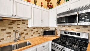A modern kitchen with white cabinets, a stainless steel microwave, a gas stove, and a sink. - Lakefront Viking Oasis Condo - Lakefront, Indoor Pool, Hot Tub (Big Bear Lake)