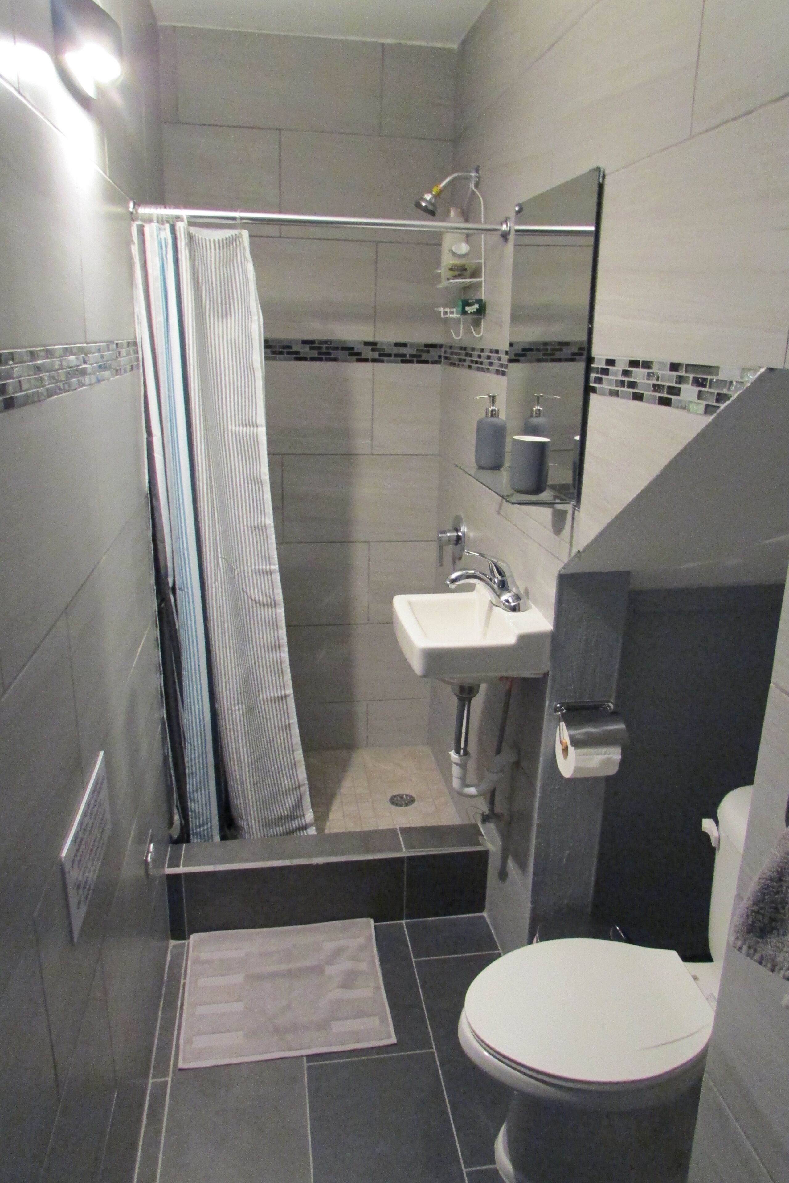 Une salle de bain moderne avec une douche à parois de verre, des toilettes et un lavabo.