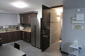 A modern kitchen with dark cabinets, a stainless steel refrigerator, and a tiled backsplash. - Perfect for relax time (La Parguera)