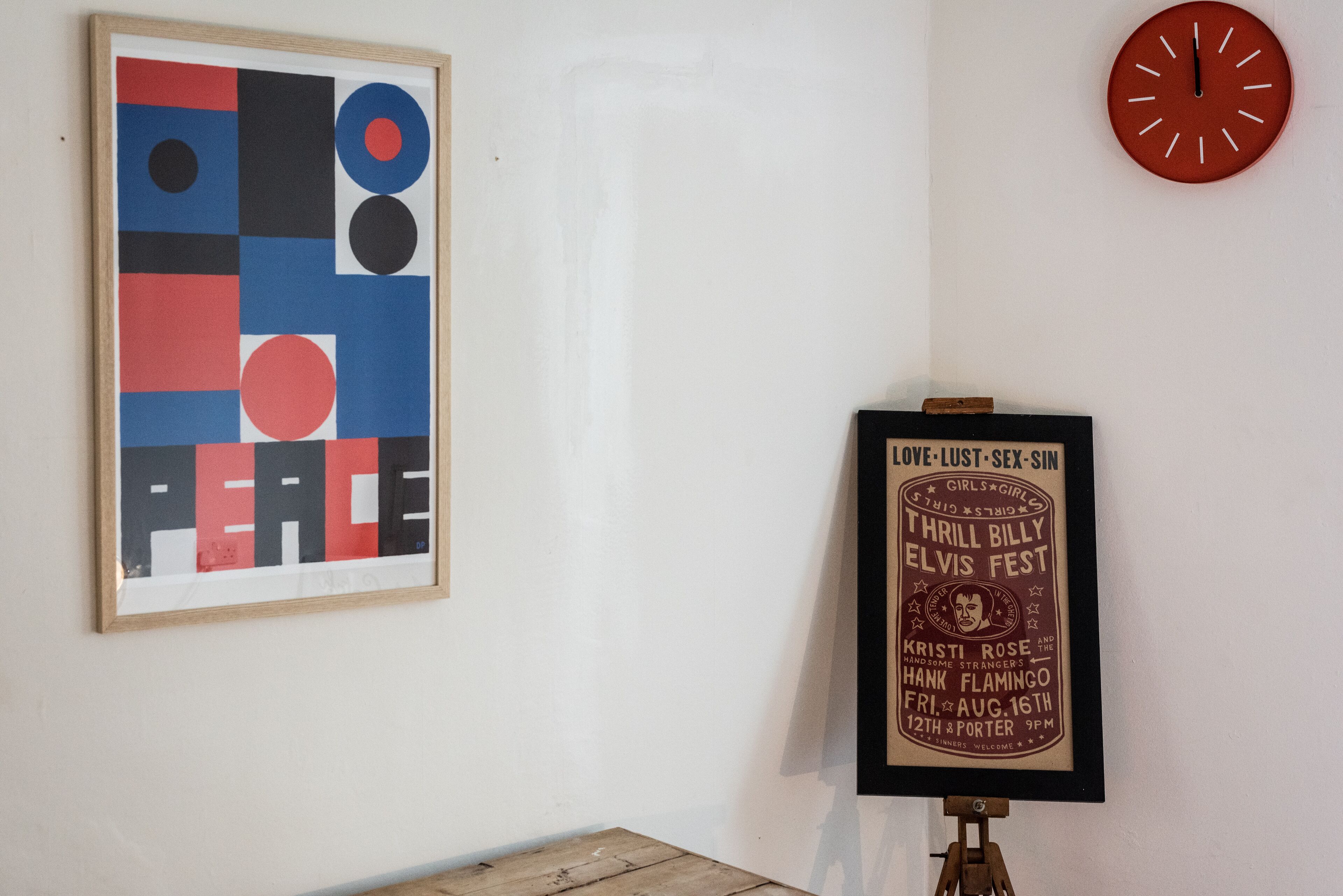 Une œuvre d’art abstraite encadrée et une affiche accrochées au mur.