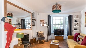A cozy living room with a fireplace, a television, and a large mirror. - Birch at Ship St Gardens (Brighton)