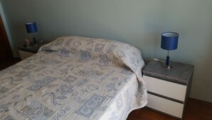 A bedroom with a bed, two bedside tables, and two lamps. - 100 m2 apartment in Olhão, central, for rent. (Olhão)