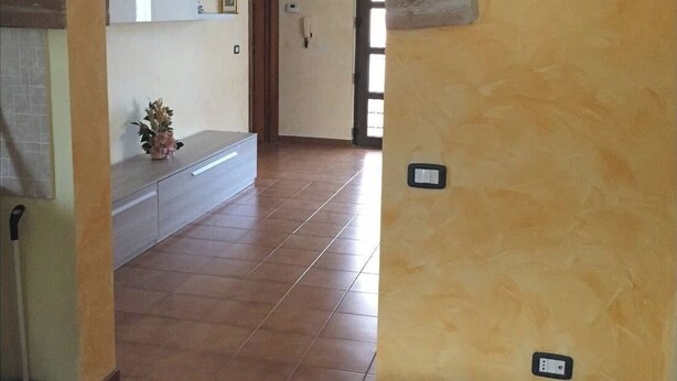 A hallway with a tiled floor, a bench, and a door leading to another room. - Quiet and peaceful Independent Villa (Castel di Sangro)