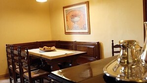 Ein Essbereich mit einem Holztisch, Stühlen, einer Vase mit Blumen und einem gerahmten Bild an der Wand.