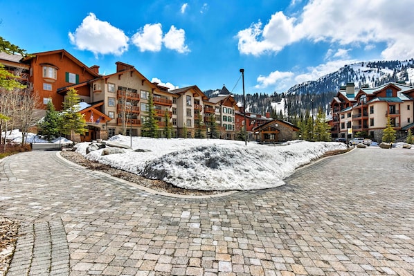Un área pavimentada cubierta de nieve con edificios al fondo.