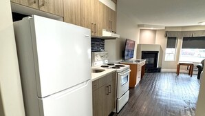 Una cocina moderna con armarios de madera, un refrigerador blanco, una estufa y una chimenea.