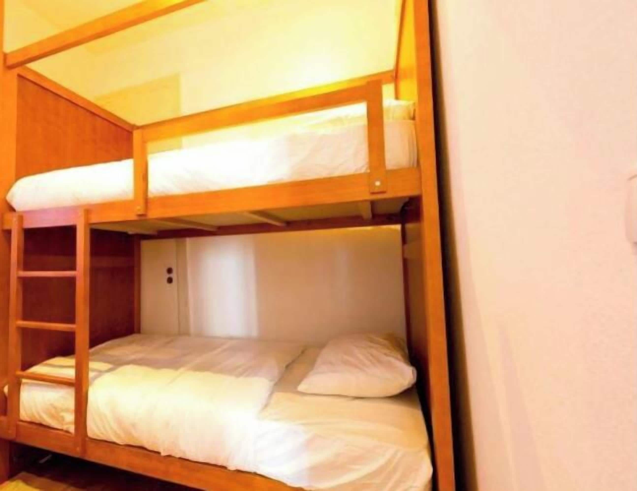 Een stapelbed met een ladder en een klein plankje.