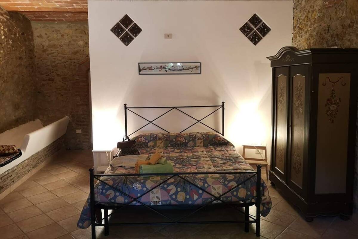 Ein Schlafzimmer mit Bett, Nachttisch, Kommode und einer Wandleuchte.