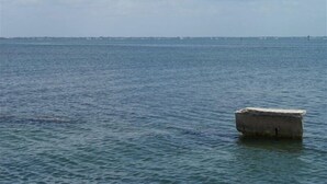 Ruhiges Meer mit einem kleinen Boot in der Nähe des Ufers.