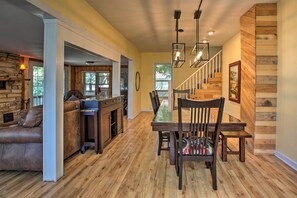 Enjoy meals in this inviting dining area with a wooden table and chairs, complemented by a chandelier.