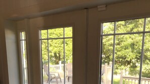 Une pièce dotée d’une grande porte-fenêtre coulissante donnant sur une terrasse extérieure.