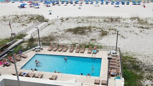A swimming pool with lounge chairs and umbrellas on a beachside property.
