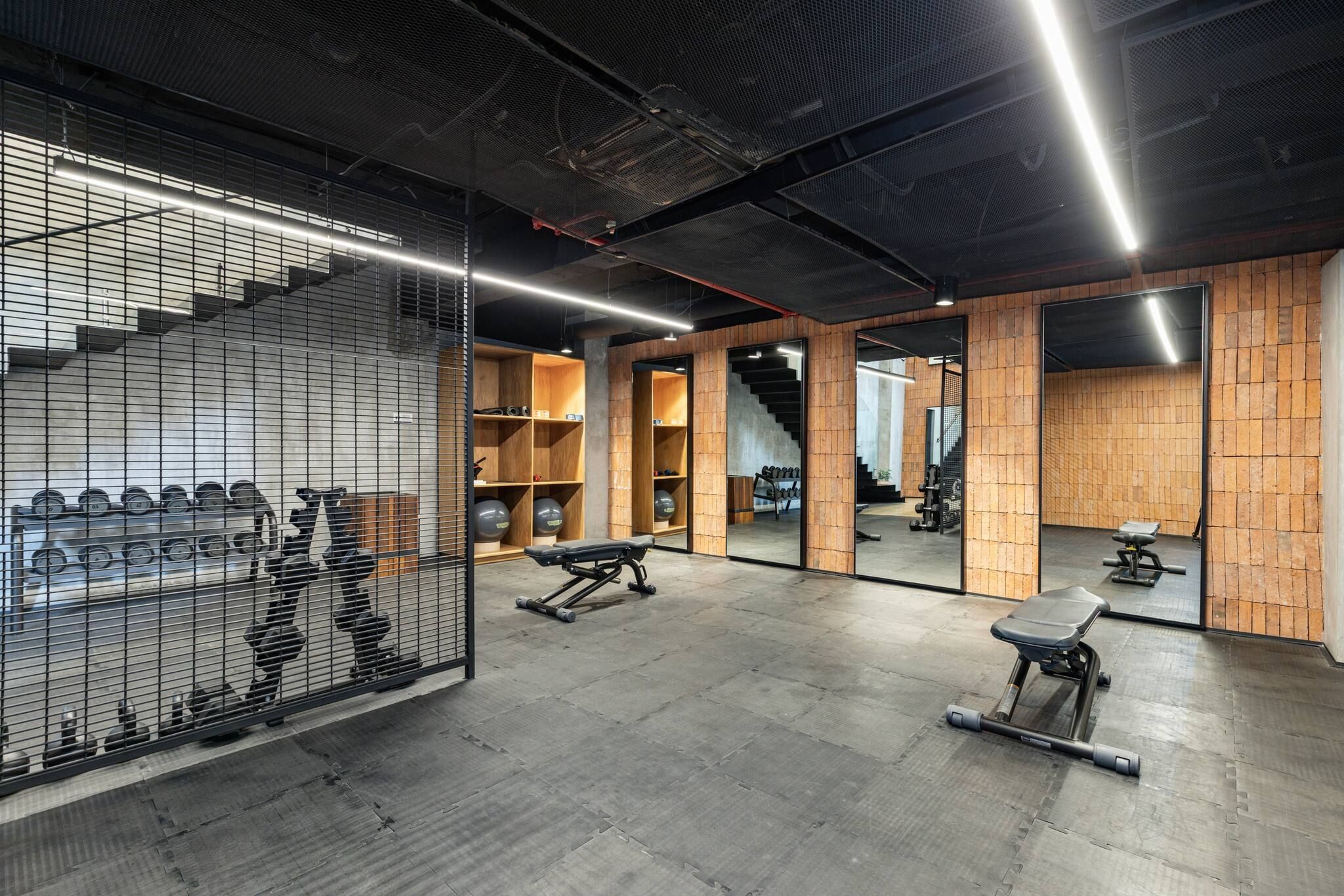 A gym with exercise equipment, wooden walls, and a mirrored wall.