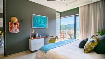 A modern bedroom with a large bed, a desk, and a view of a cityscape.