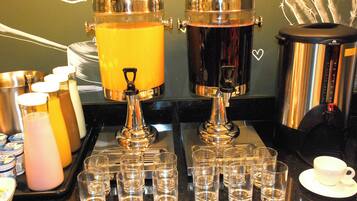 A coffee station with two coffee dispensers, multiple cups, and a tray with glasses.