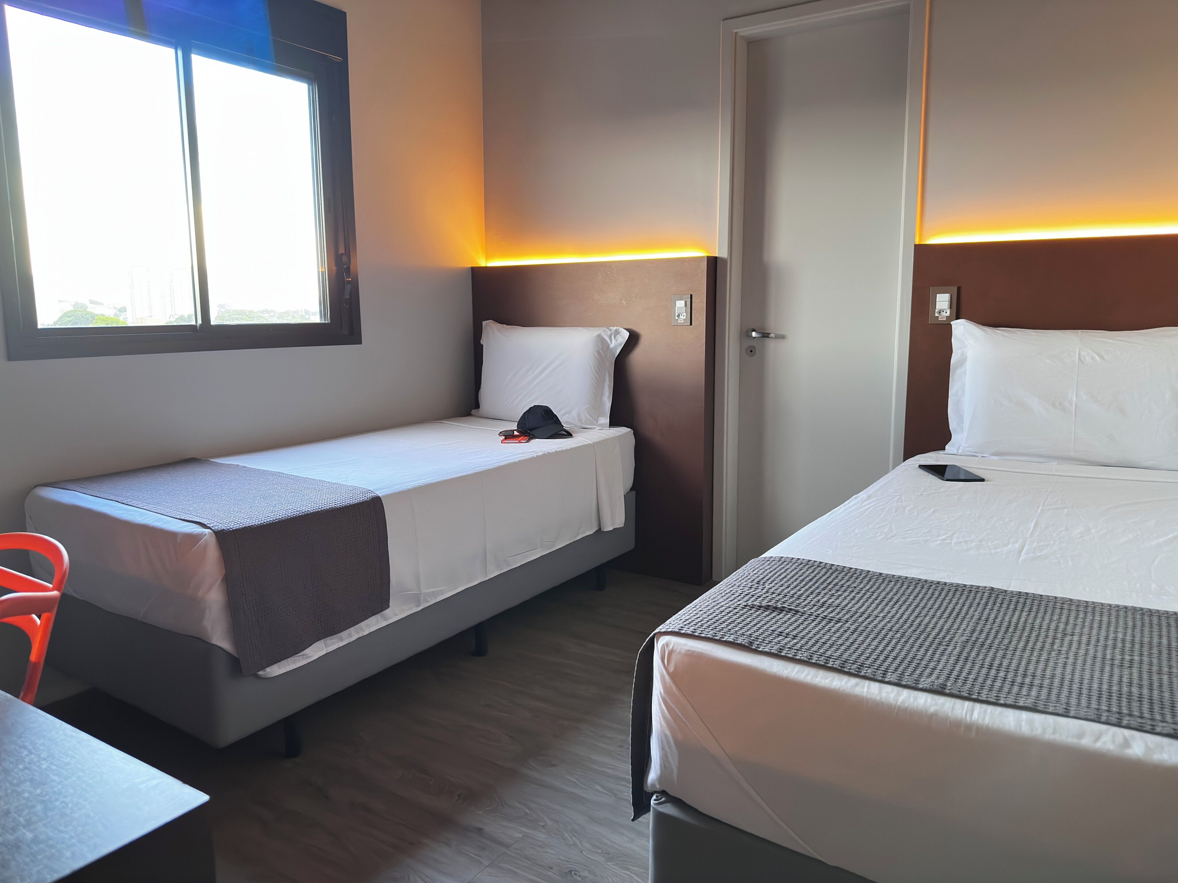 Una habitación de hotel con dos camas individuales, un escritorio y una silla.