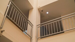 A multi-level interior with balconies, staircases, and ceiling lights.