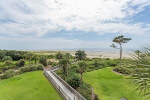 Paisagem costeira com um caminho que leva a uma praia.