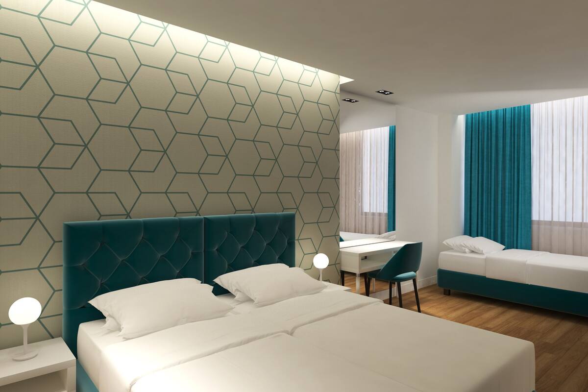 Moderni hotellihuone, jossa on suuri sänky, työpöytä ja sohva.