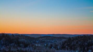 Un paysage boisé, avec un ciel dégagé au crépuscule.
