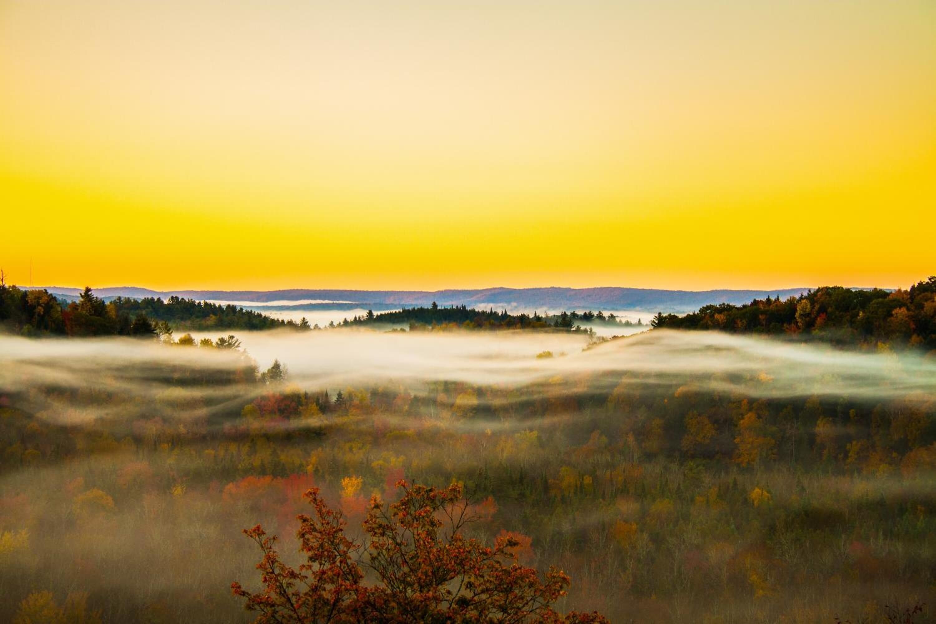 A landscape with a valley and distant hills.