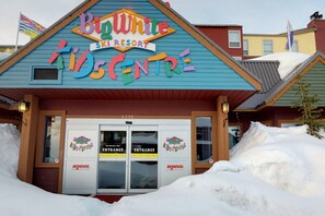 Welcome to the Big White Ski Resort's Kids Centre, featuring a vibrant entrance with glass doors.