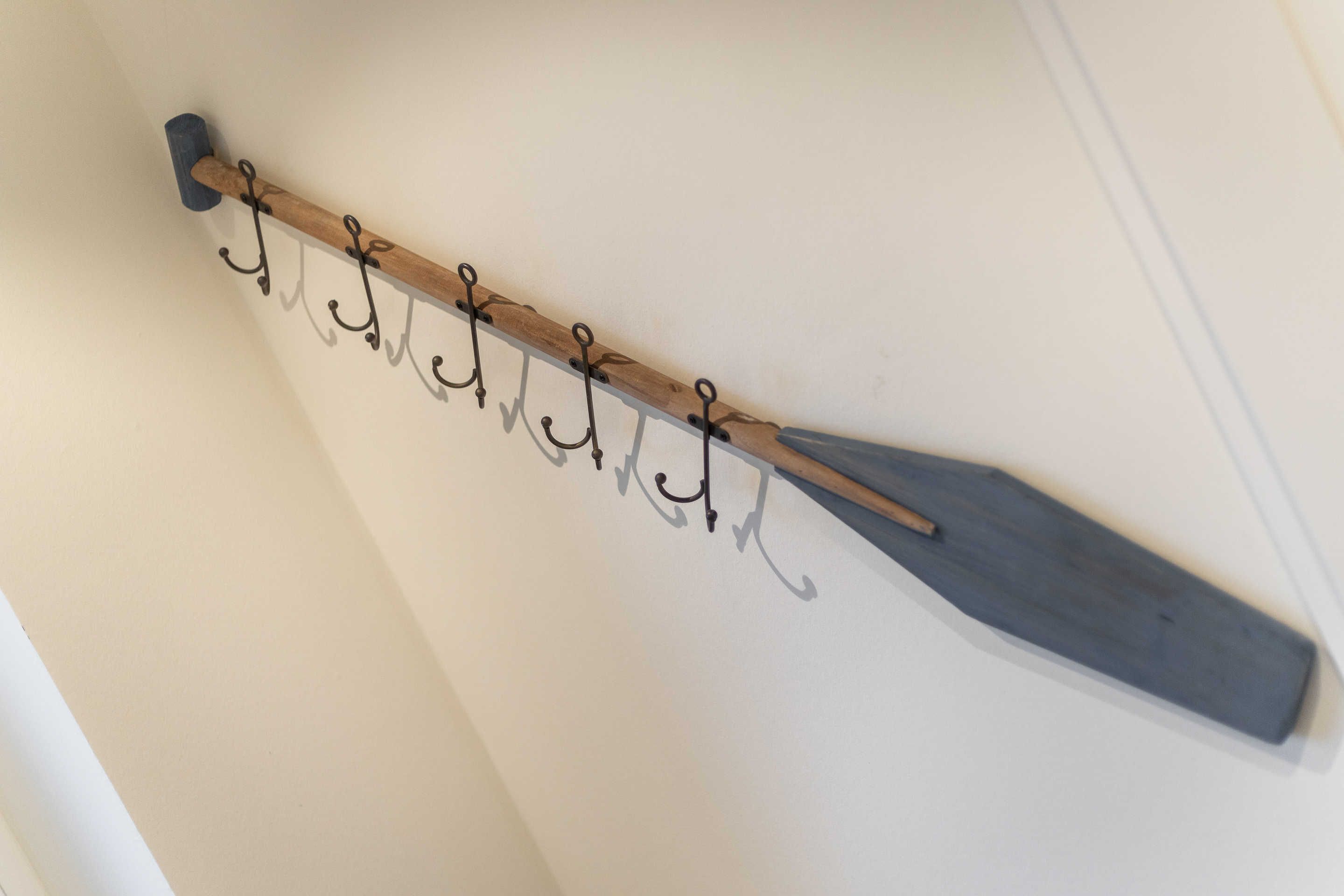 A wall-mounted coat rack with hooks.