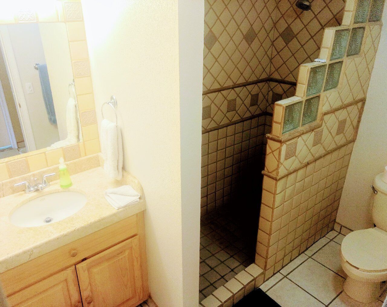 Ein Badezimmer mit Waschbecken, Spiegel und Toilette.