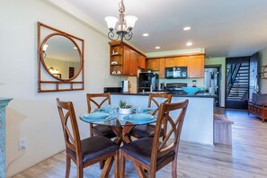 Enjoy cooking in this well-equipped kitchen with a central island, dining area, and staircase to the upper level.