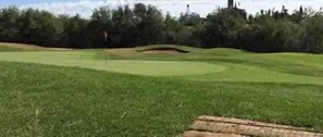 Un campo da golf con un cartello per il Castle Oaks Golf Club.