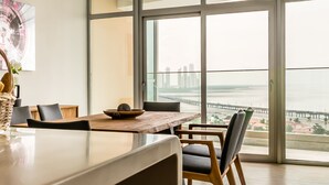 A modern dining area with a view of a bridge and cityscape. - Panoramic Apartment Ocean View (Panama City)