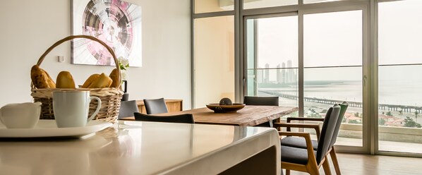 A modern dining area with a view of a bridge and cityscape.