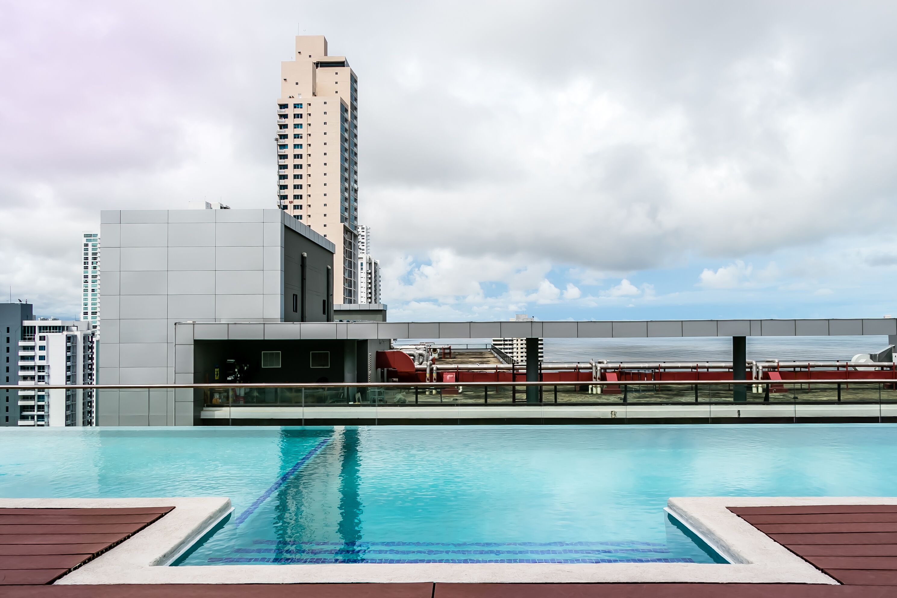A rooftop pool with a view of a tall building and a bridge.