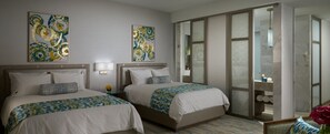 A hotel room with two beds, a large window, and artwork on the walls.
