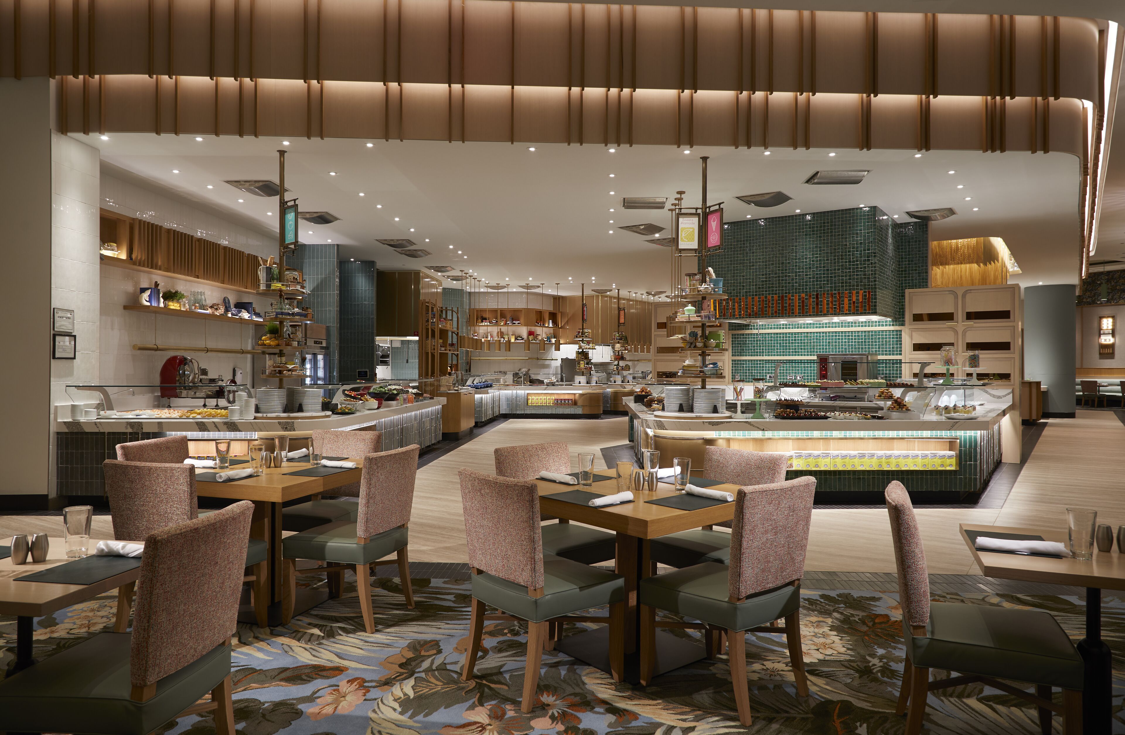 A modern restaurant with a central bar area, multiple seating options, and a variety of food displays.