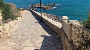 A stone pathway leading to the sea with a railing on one side and lamp posts along the path. - Beachfront apartment with spectacular views
About this space (Oropesa del Mar (Castellón))