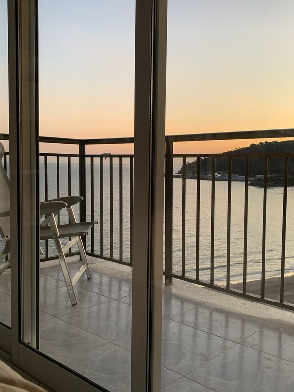 Un balcón con vista al mar al atardecer.