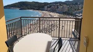 A balcony with a table and chairs overlooking a beach and cityscape. - Beachfront apartment with spectacular views
About this space (Oropesa del Mar (Castellón))